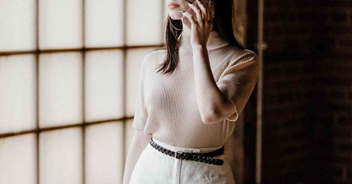 woman talking on the phone in white jeans and a short-sleeved sweater